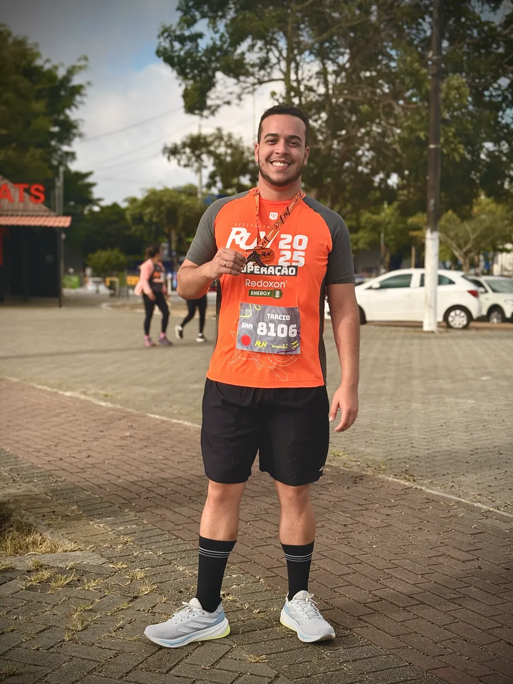 Tarcio Diniz com a camisa e a medalha de uma corrida