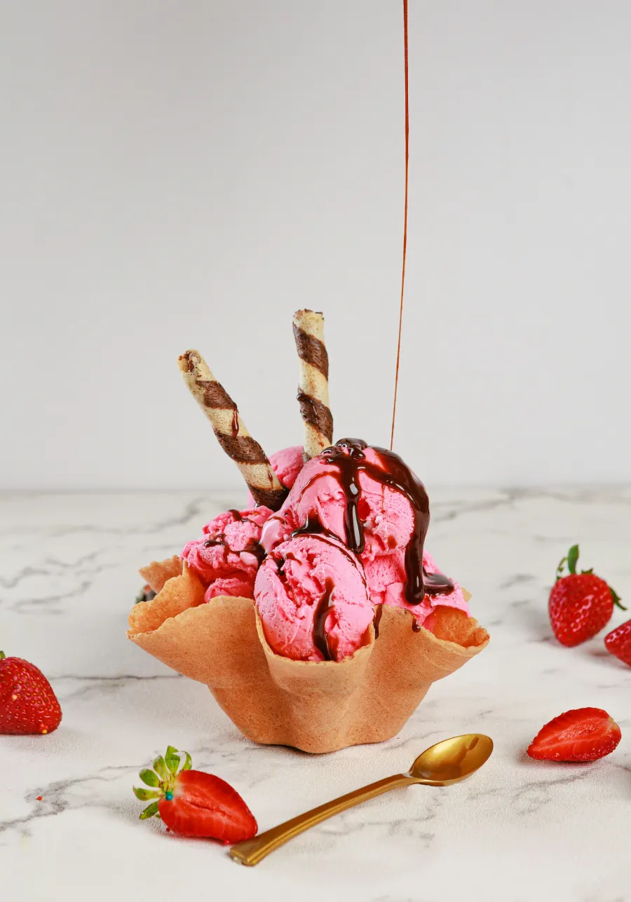 Cestinha de waffle com sorvete de morango, barquilhos e calda de chocolate