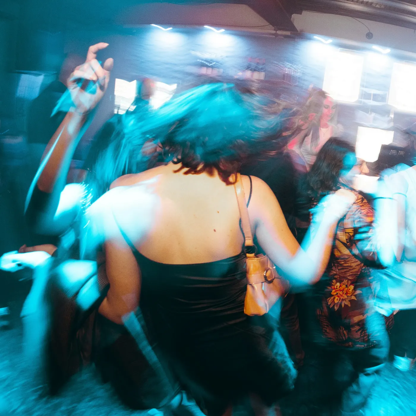 Pista de dança em movimento sob luz azul e ciano