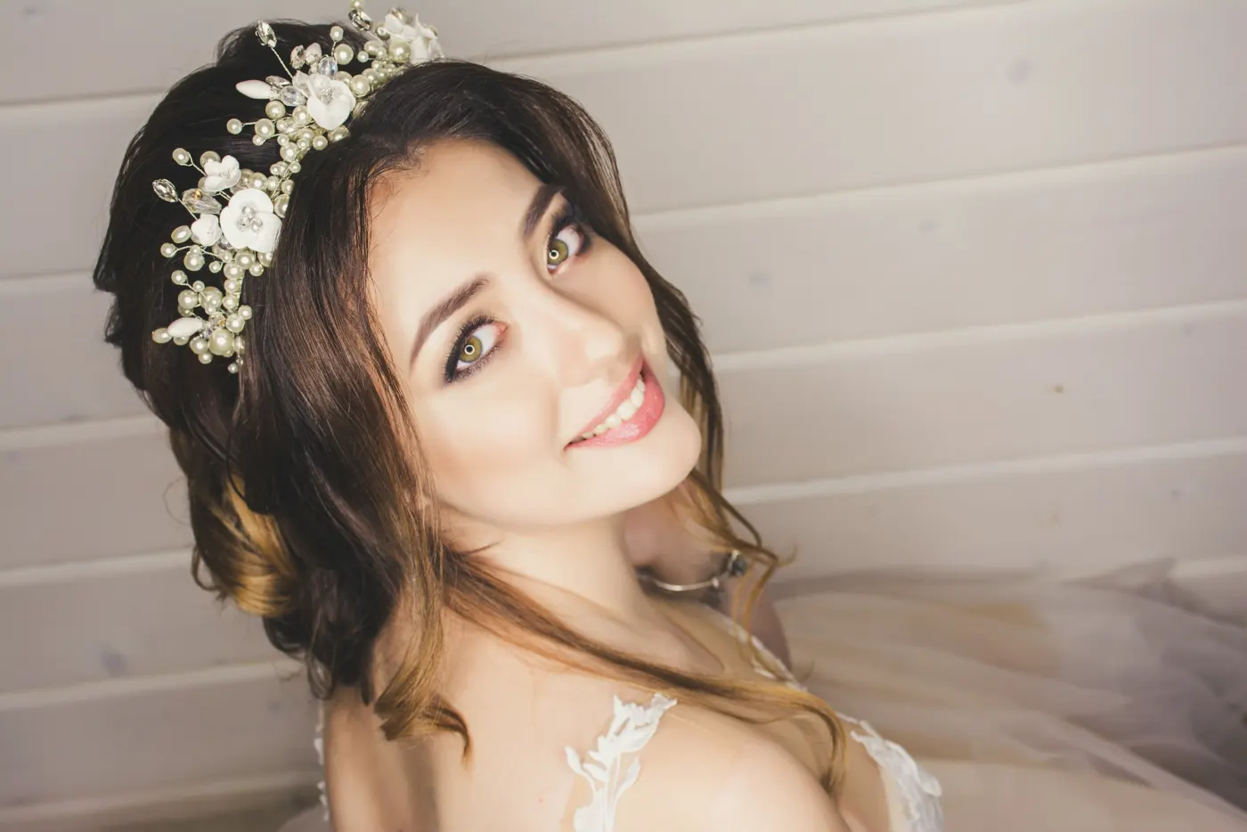 Noiva sorrindo com arranjo de flores brancas no cabelo