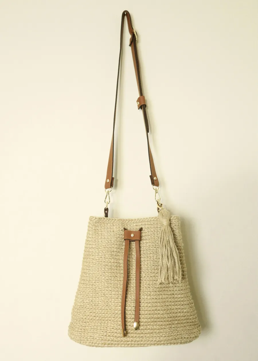 Bolsa de palha clara com alça longa de couro e franja