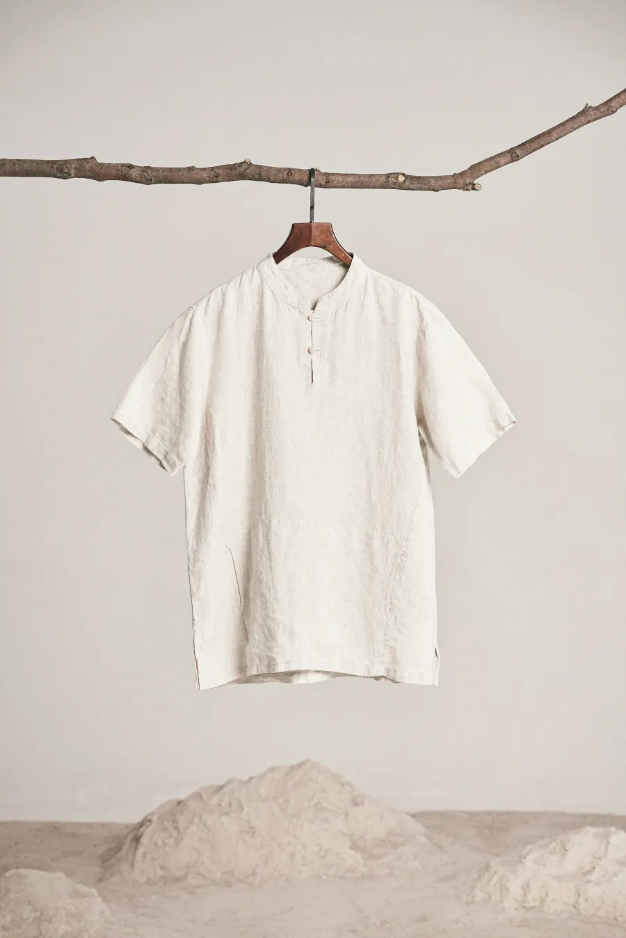 Camisa de linho branco de manga curta pendurada em um galho