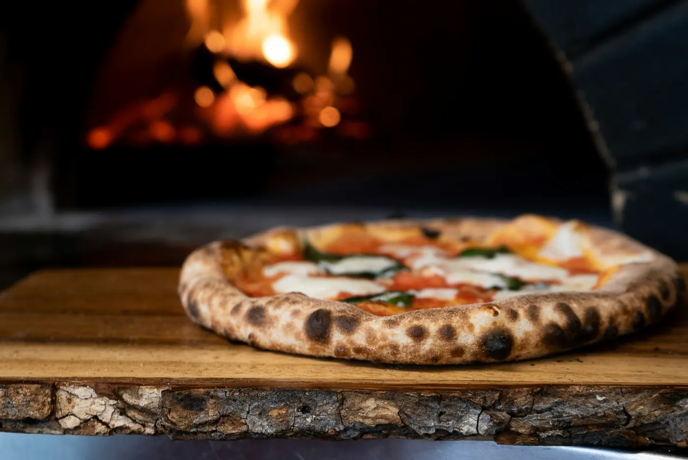 Pizza de lenha diante do fogo do forno