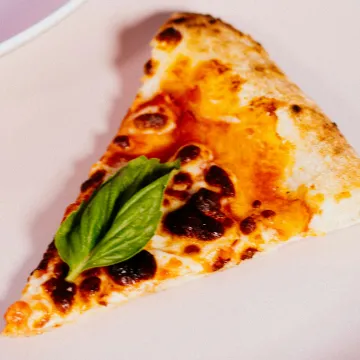 Fatia de pizza margherita com manjericão e o queijo pintado de forno