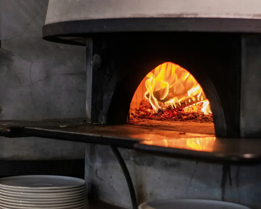 Boca de um forno a lenha com fogo aceso