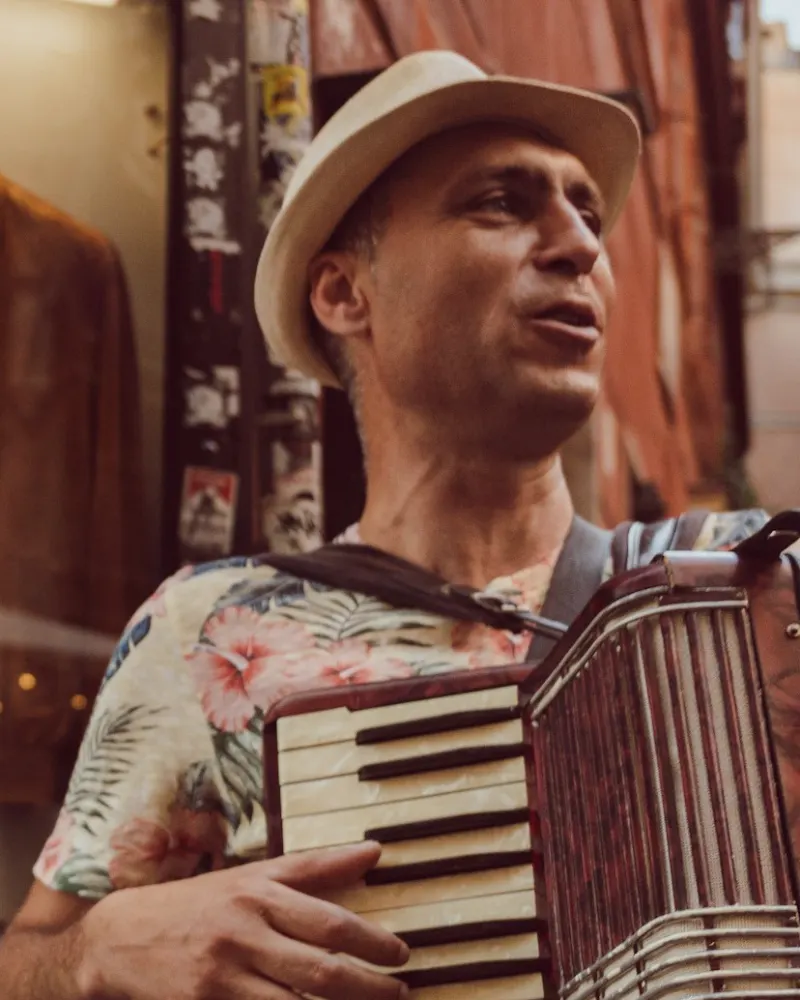 Sanfoneiro de chapéu de palha cantando com a sanfona no peito